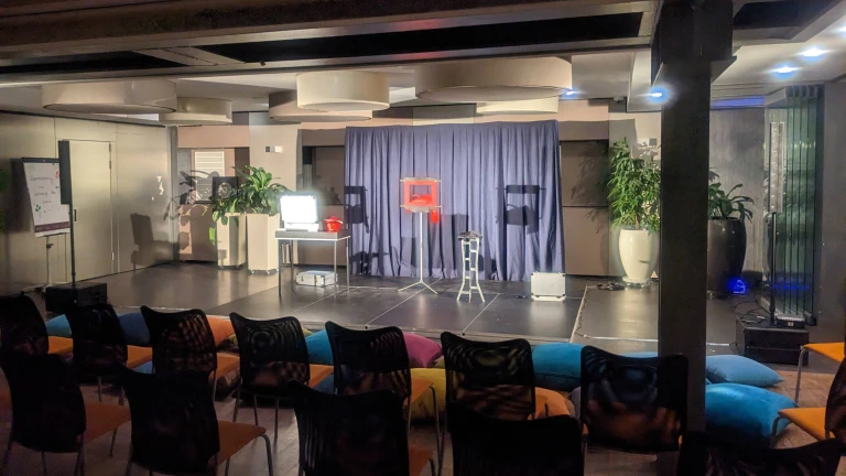 Hotelowa sala konferencyjna przygotowana do pokazu iluzji z mobilną kurtyną, magicznymi rekwizytami oraz krzesłami dla widowni