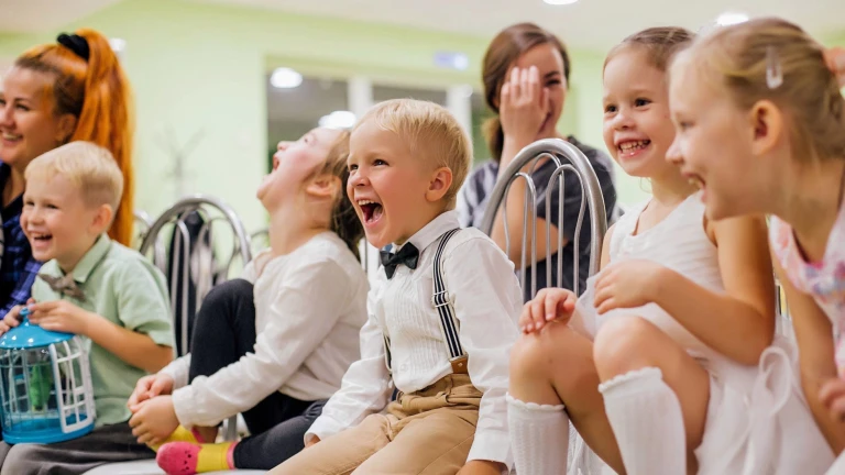 Roześmiane i zadowolone dzieci z przedszkola oglądające pokaz iluzji
