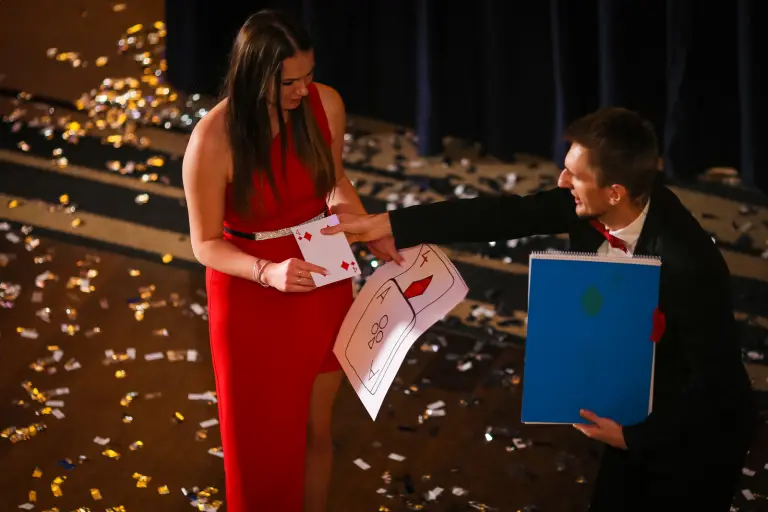 Iluzjonista Konrad Mościński wykonujący sztuczkę z udziałem widza podczas nocy sylwestrowej